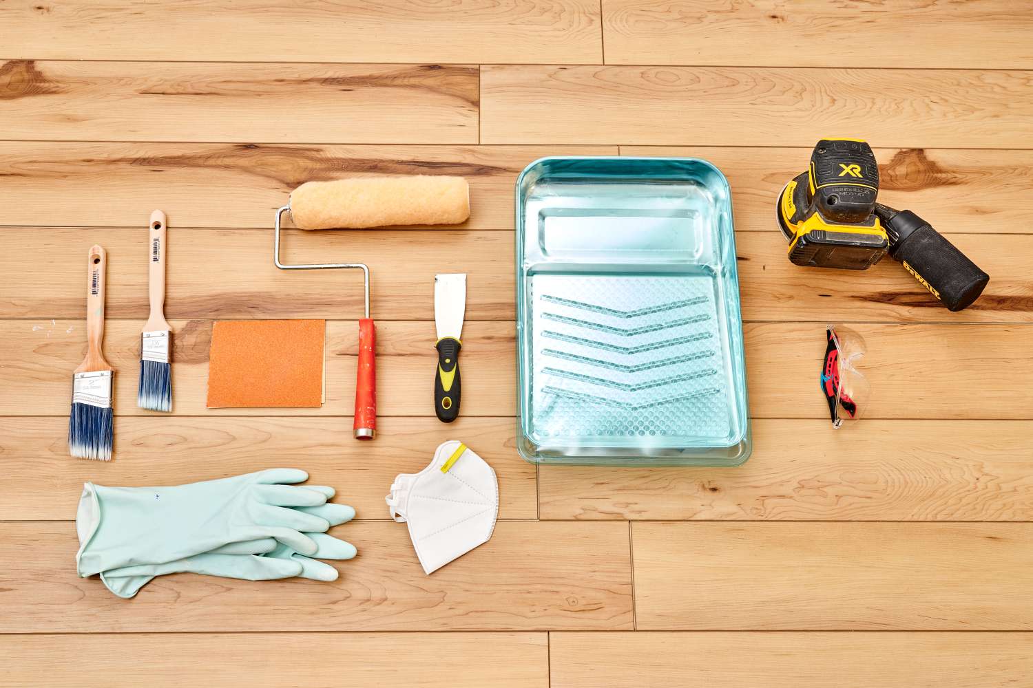 Aerial perspective of supplies and equipment for painting backsplash tiles.