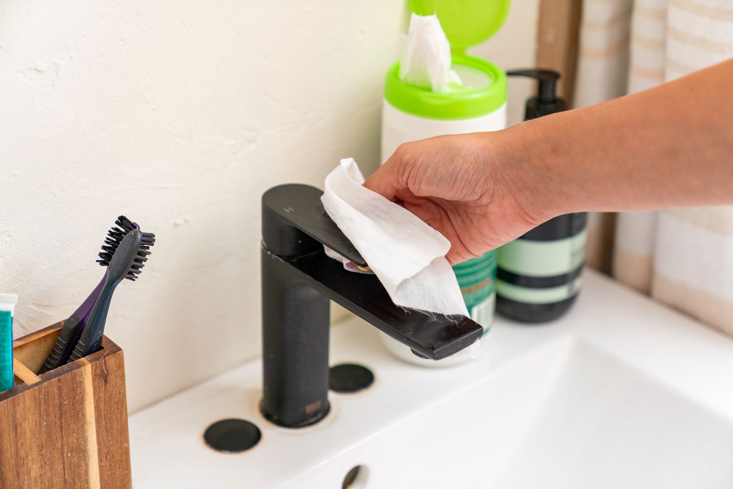 The bathroom sink faucet was cleaned using a disinfectant wipe.