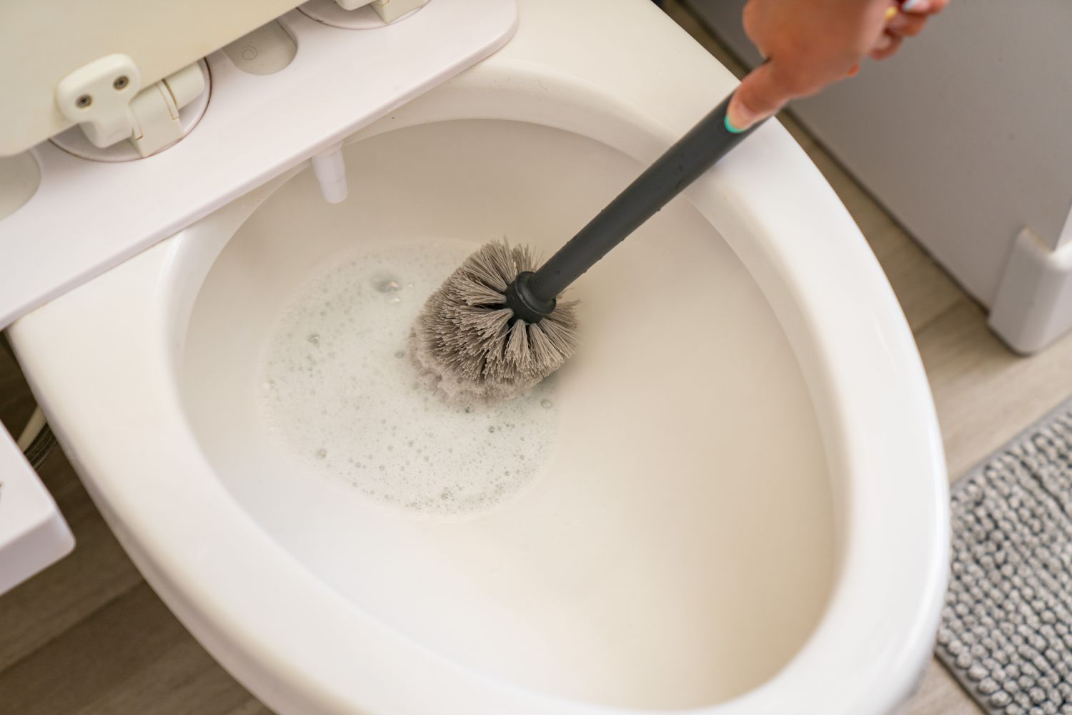 The toilet bowl has been sanitized using a versatile bathroom cleaner and a scrubbing brush.