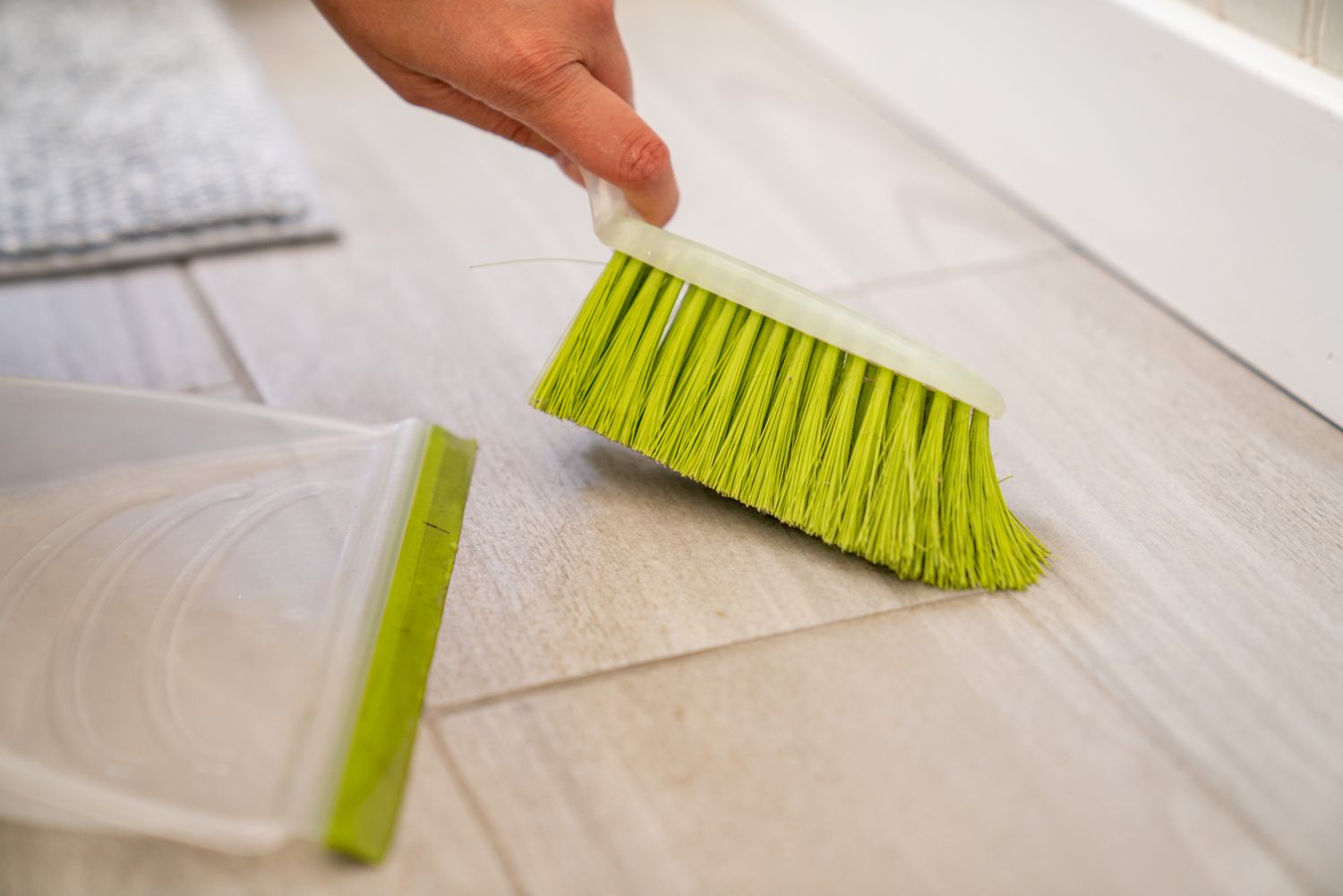 The bathroom floor is cleaned weekly using a hand-held brush.