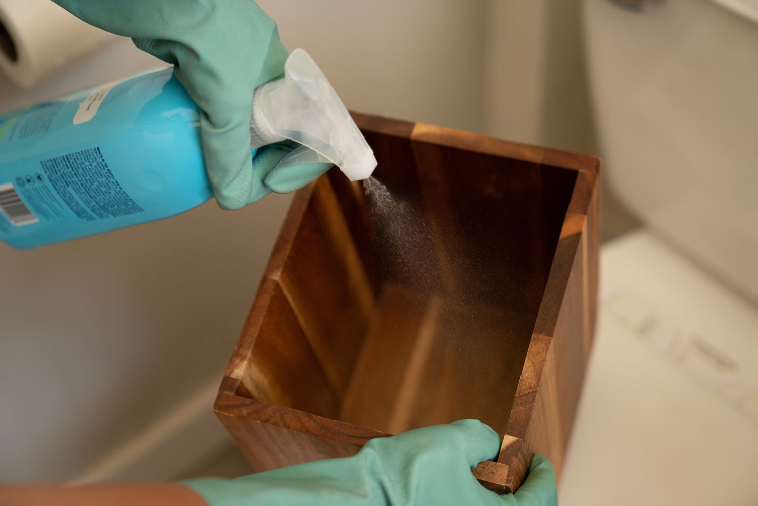 A wooden waste bin treated with an all-purpose cleaning spray.