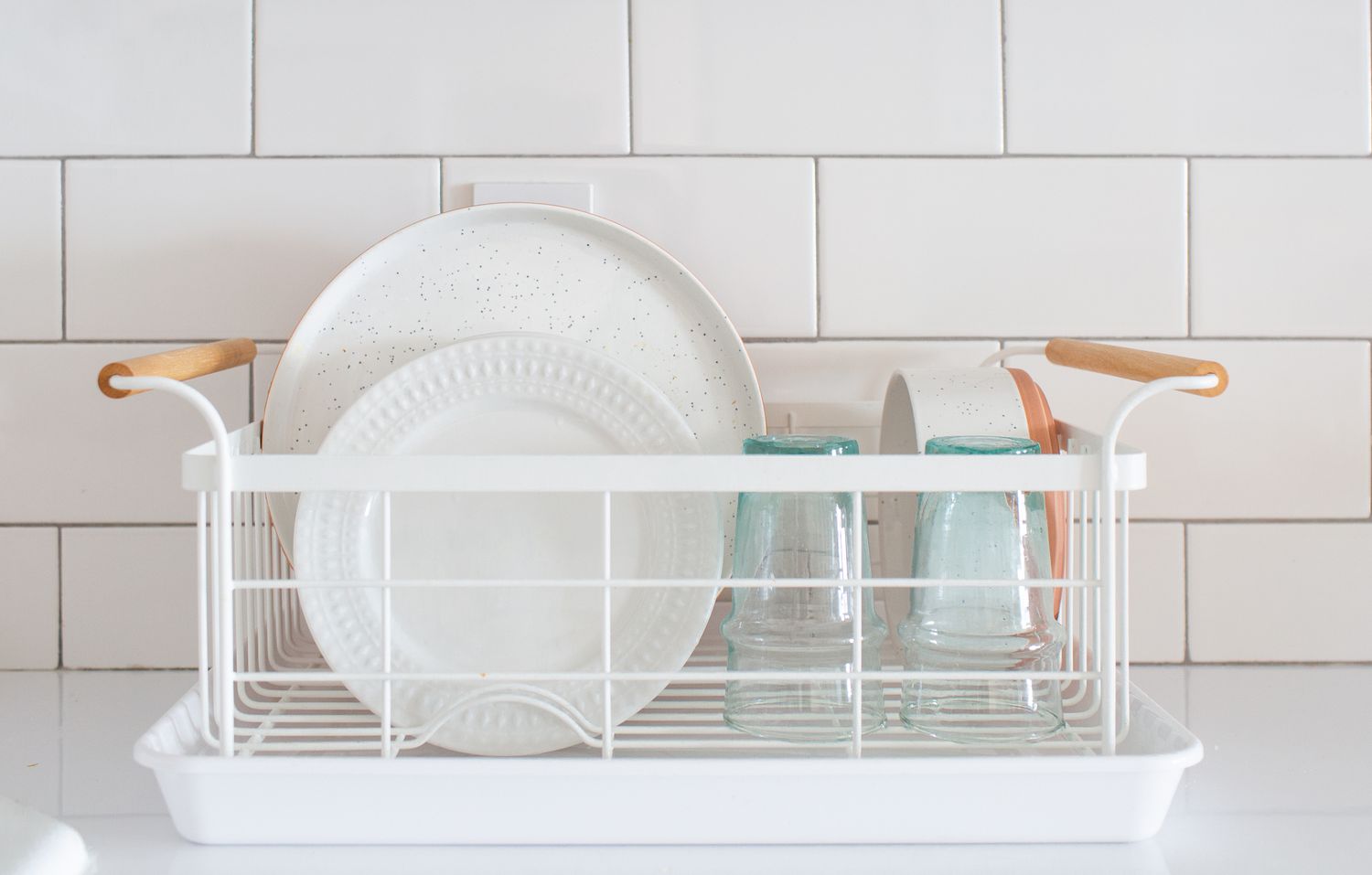 plates and utensils air-drying on a dish drainer