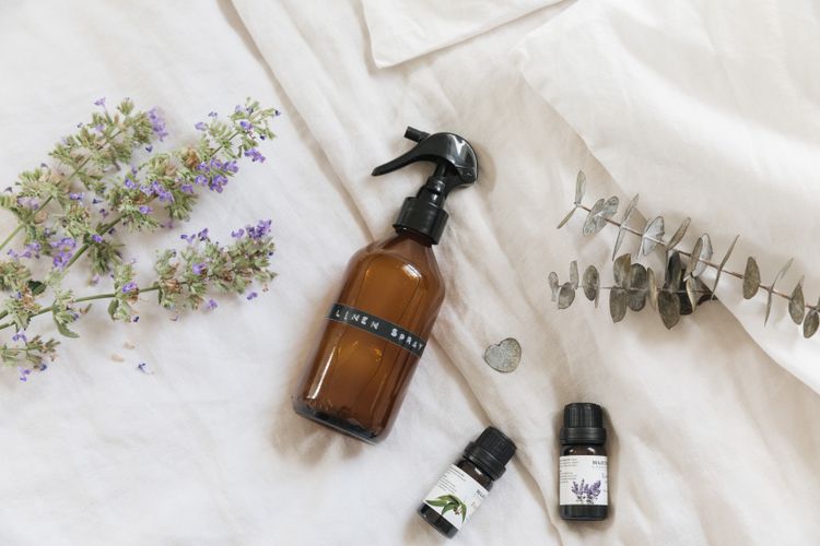 Homemade linen mist in a bottle placed on a white textile.