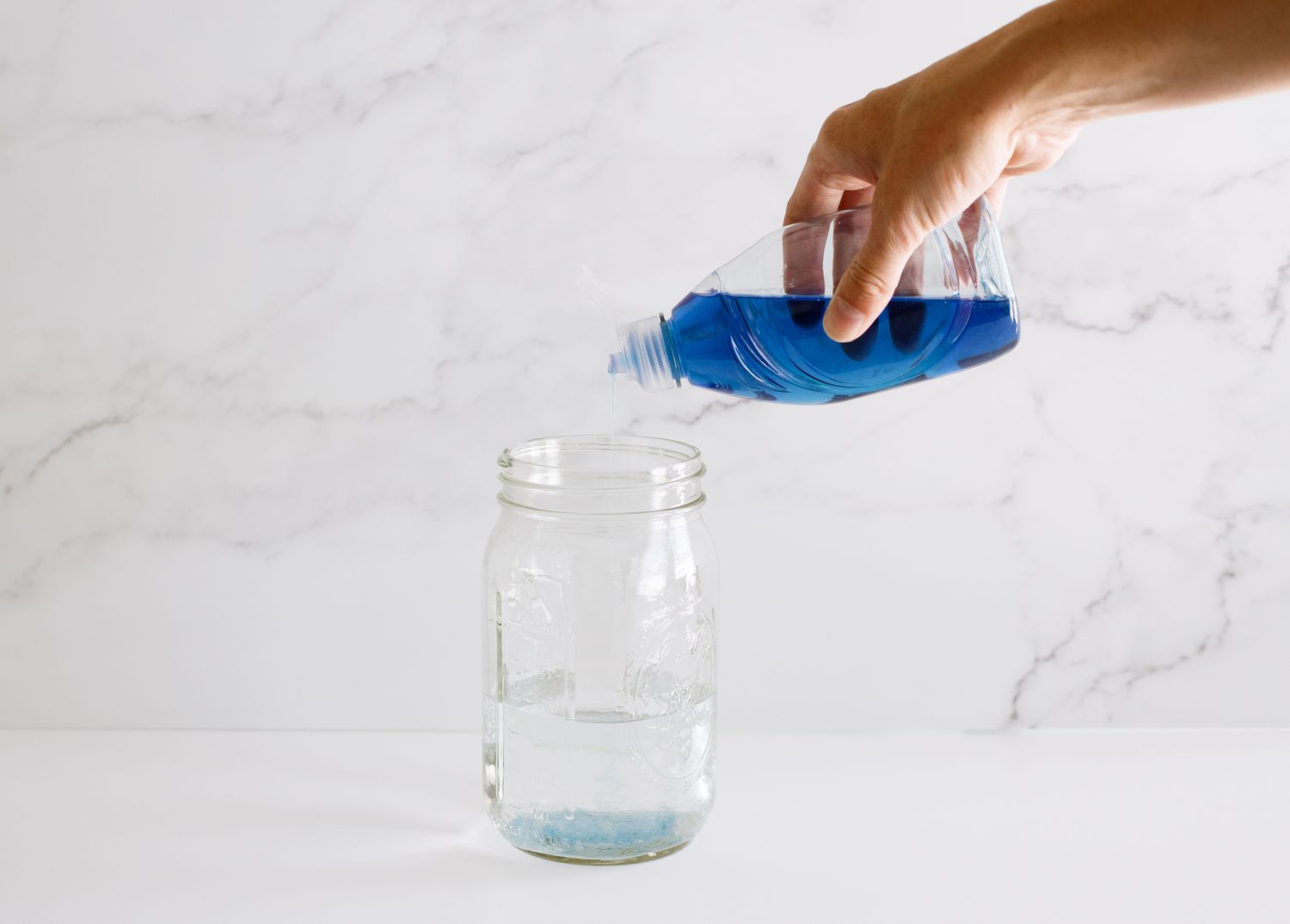 Dish soap mixed into a glass container filled with water.