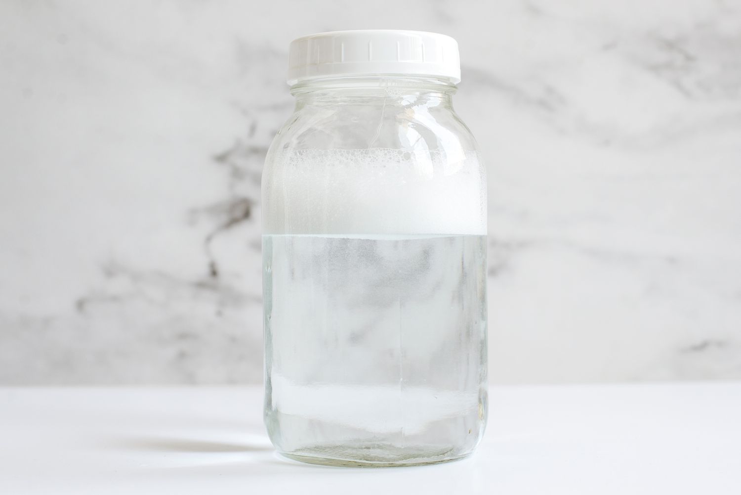 A spacious transparent container filled with water and soap bubbles to check for hard water.