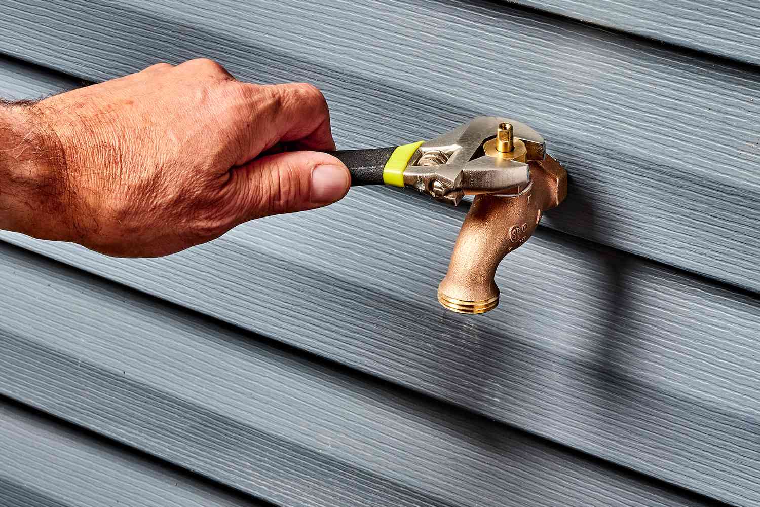 Loosen the packing nut located at the top of the faucet body using a wrench.