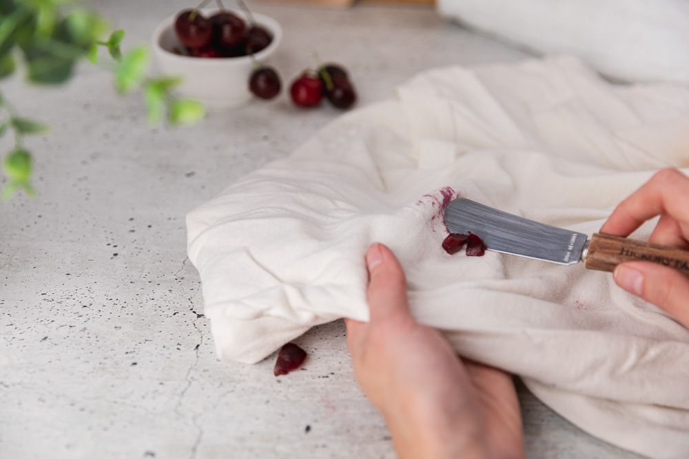 Cherry pulp extracted from white fabric using a blunt knife.