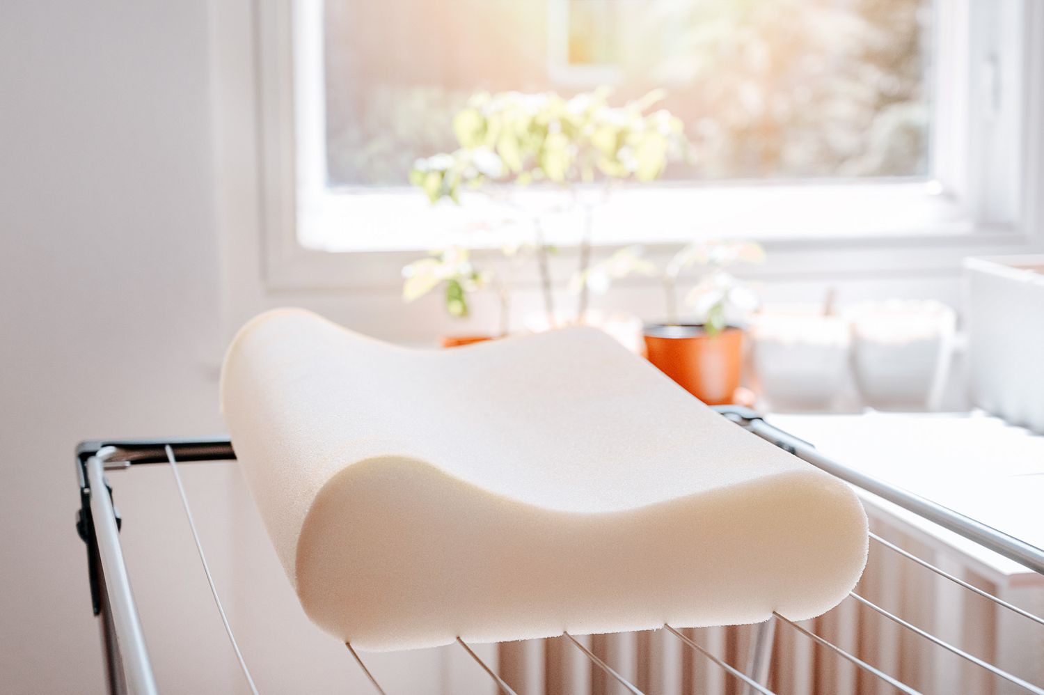 A memory foam pillow for the bed is laid out on a drying rack to allow for air drying.